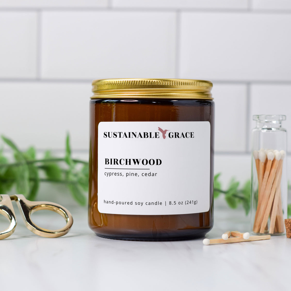 birchwood scented soy candle from sustainable grace in amber colored jar with gold lid
