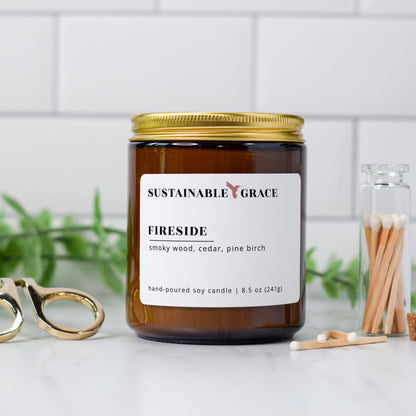 fireside smoky wood scented candle in amber glass jar with gold lid